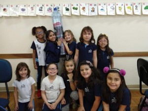 Educandos seguram o Saci preso dentro da garrafa